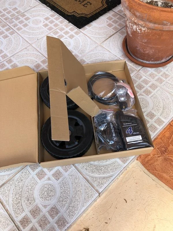 Caja de accesorios: ruedas, manguera para gas y aceite, foto real